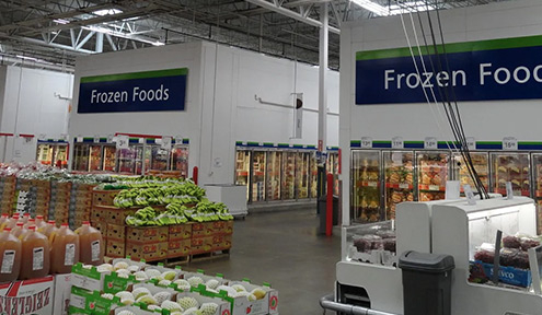 Interior of a grocery store showing the Frozen Foods section, with colorful product displays and organized freezer cases.